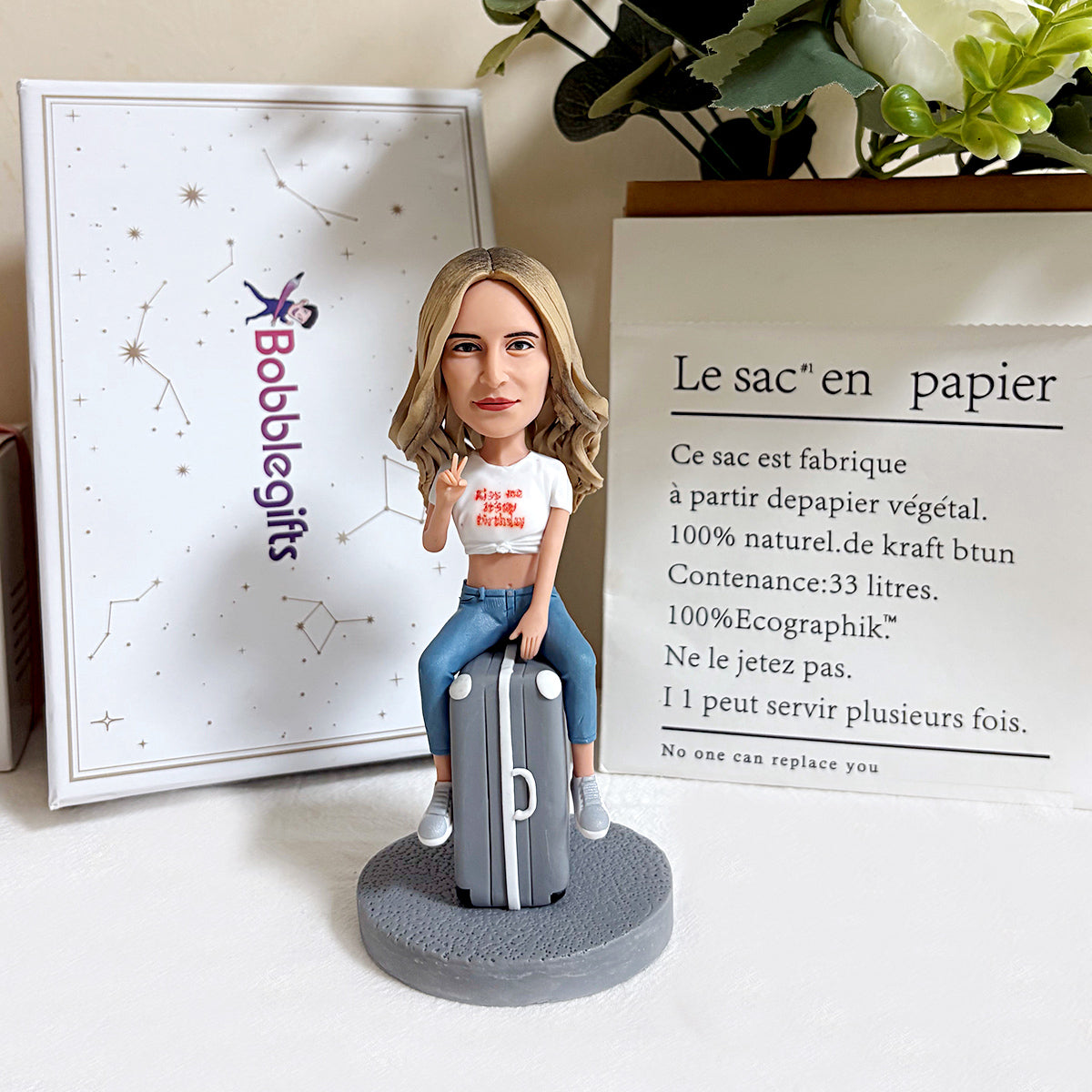Aangepaste bobblehead zittend op een koffer