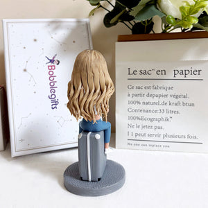 Aangepaste bobblehead zittend op een koffer