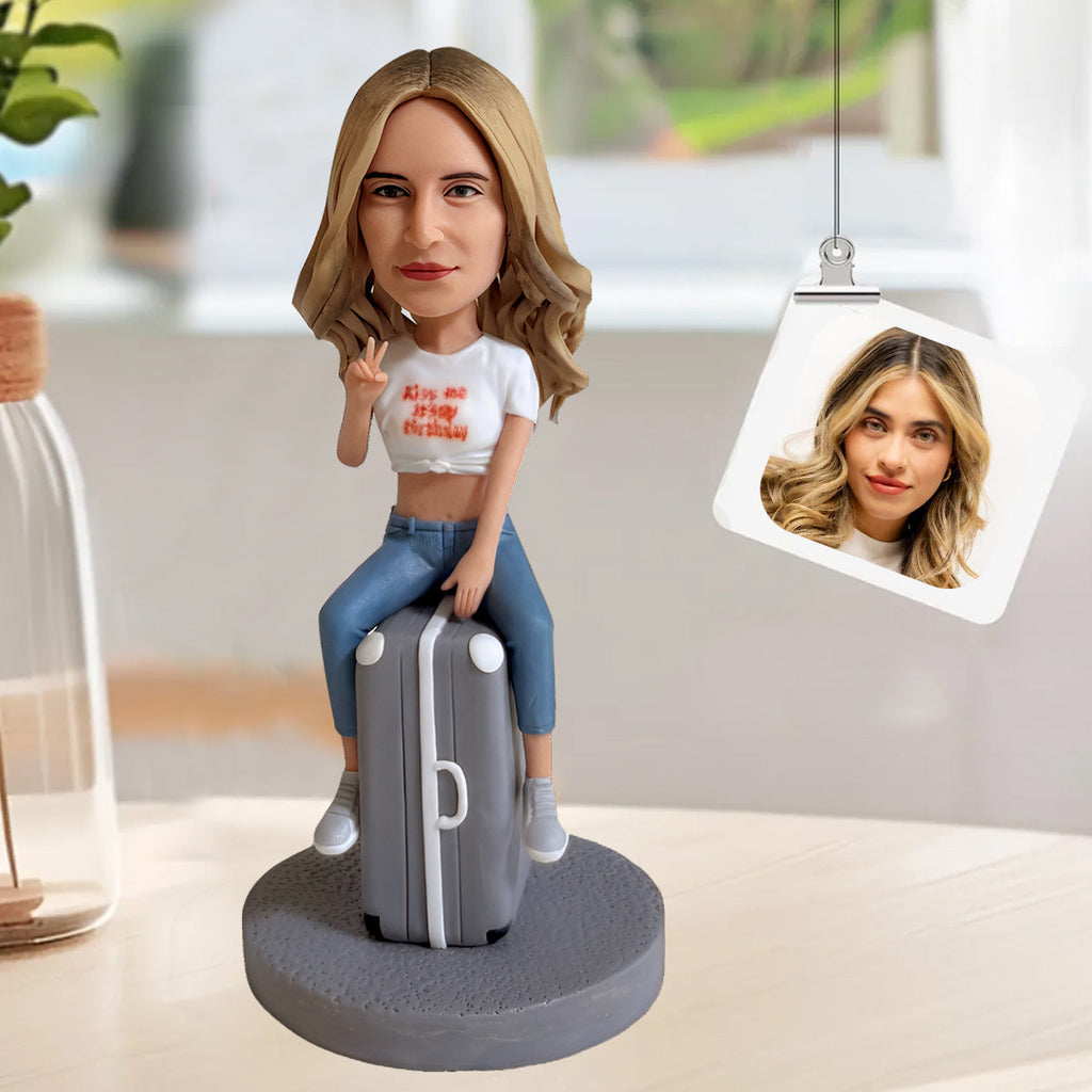 Aangepaste bobblehead zittend op een koffer