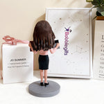 Op maat gemaakte bobblehead van een vrouwelijke accountant met rekenmachine en rapport.