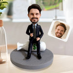 Gepersonaliseerde bobblehead in pak, zittend op een geldtas.