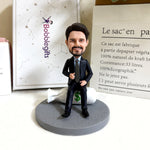 Gepersonaliseerde bobblehead in pak, zittend op een geldtas.